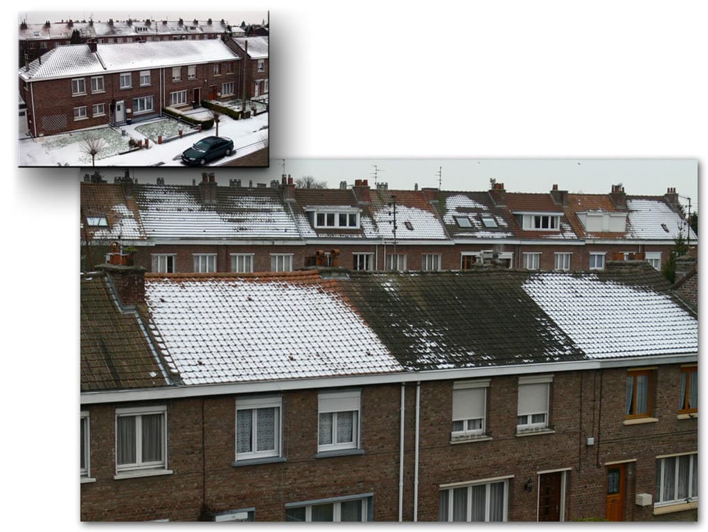 Rangée de maisons mitoyennes en hiver : la neige a fondu sur certaines toitures et tient sur d’autres