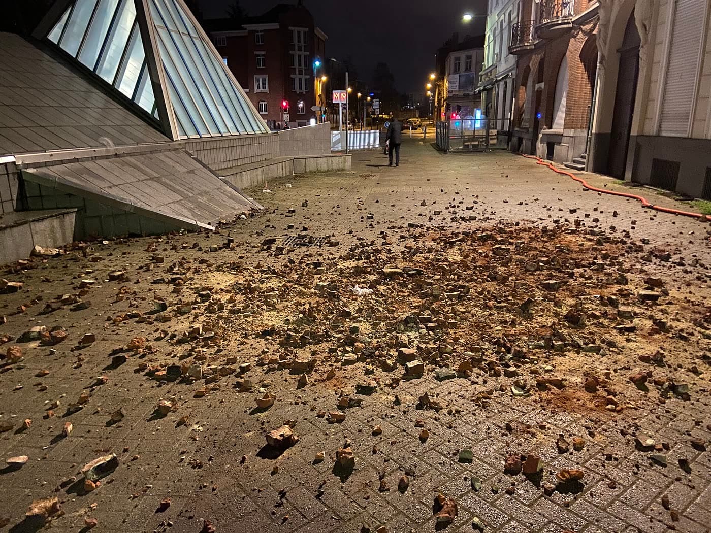 Trottoir couvert de débris de briques tombés d’une cheminée pendant une tempête, de nuit
